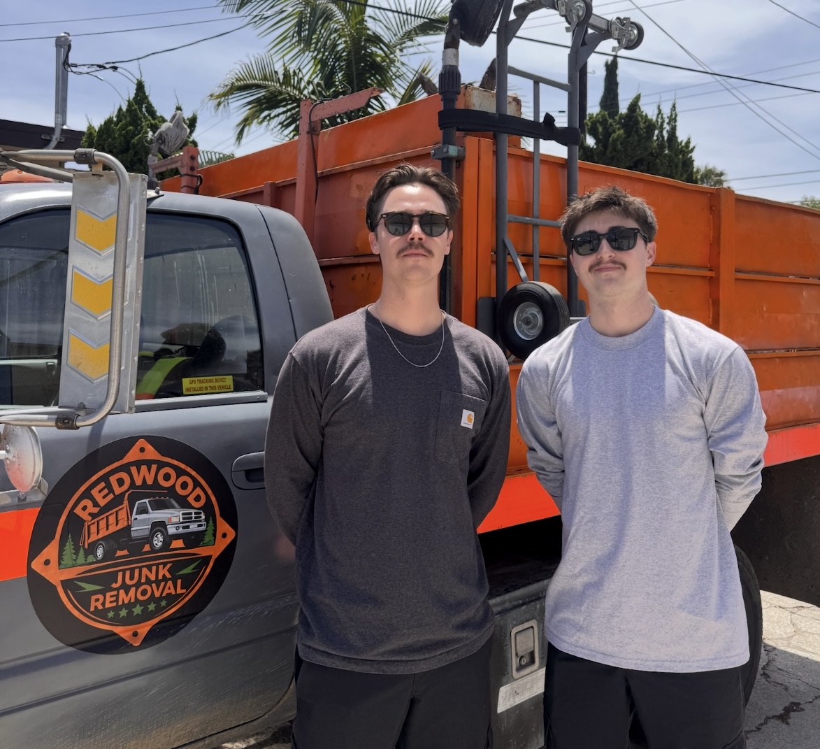 Pontus Rydell and Austin Burke, owners of Redwood Junk Removal, standing in front of their dump truck